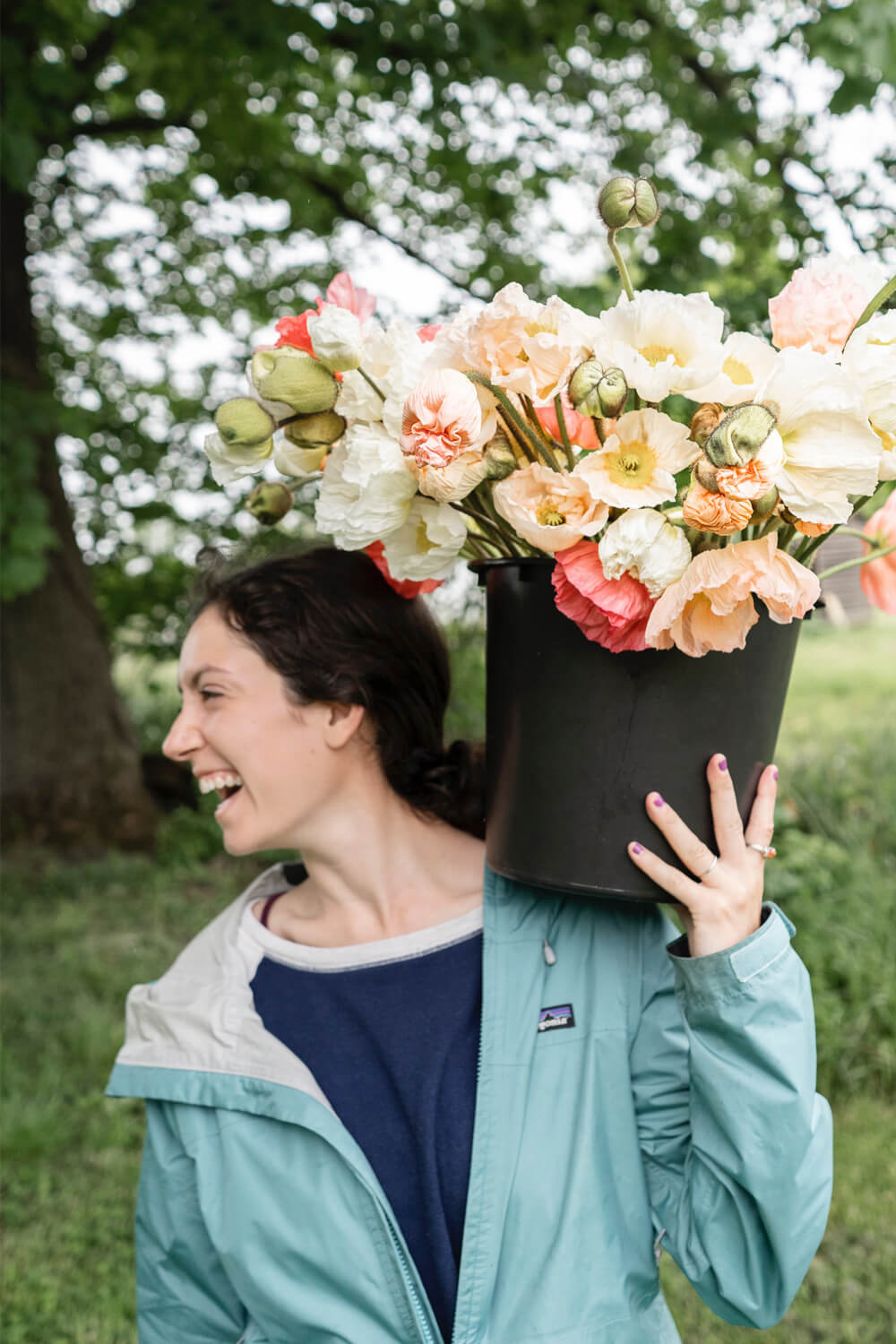 Woman holding a bucket of flowers on her shoulder